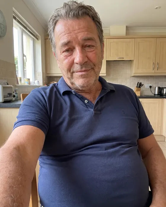 Ray, 64, taking a morning selfie in his kitchen on day 1, navy polo pulled tight over a bloated stomach, face puffy and tired