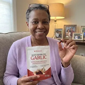 Resilia customer holding the Aged Odorless Garlic pouch