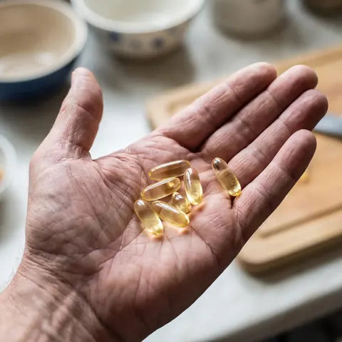 Pale yellow garlic oil softgels in a palm