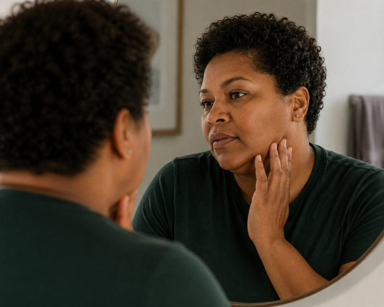 Woman in her 50s looking at herself in the mirror