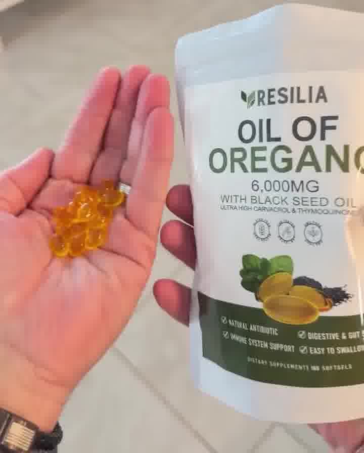 Golden Resilia softgels in a hand beside the pouch