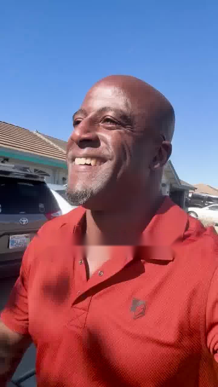 A man smiling outside in the sun